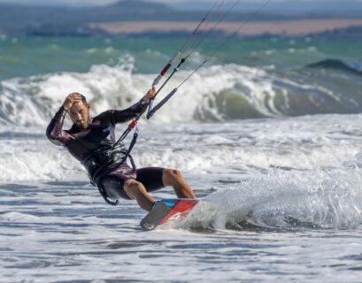 Mężczyzna uprawiający kiteboardingu na morzu.